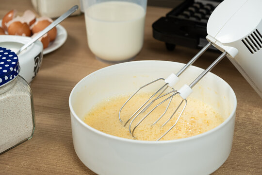The process of beating eggs with sugar with a mixer, close-up, making the dough.