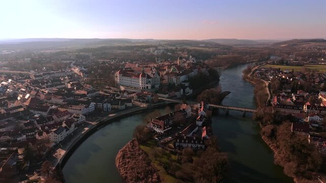 Drohnenaufnahme der Altstadt von Neuburg an der Donau in Oberbayern. Sichtbar sind das Residenzschloss, der historische Stadtkern und der Fluss Donau bei sonnigem Winterwetter.