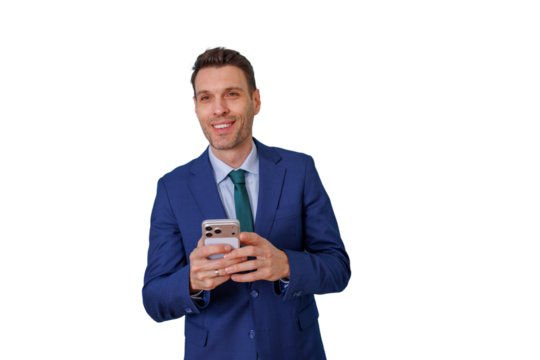 Smiling businessman in a blue suit holding a mobile phone, texting or checking messages, standing with transparent background - Powered by Adobe
