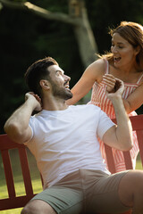 Couple in love, woman suprising man from behind in park