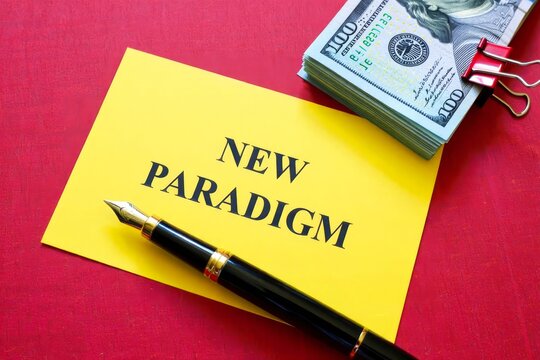 NEW PARADIGM word on a yellow piece of paper on dollars on a red background.