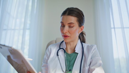 Remote doctor examining x-ray at video call in clinic pov. Woman radiologist