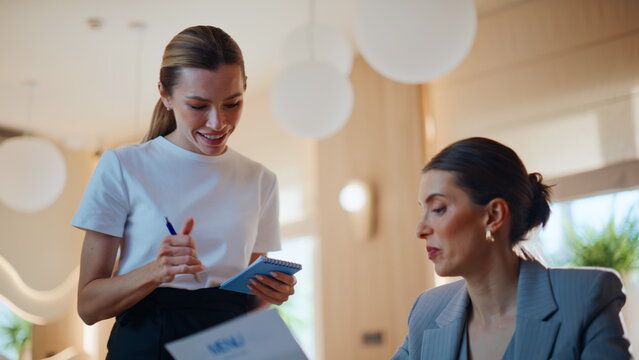 Woman interacting cafe waitress making order closeup. Cafeteria worker advising
