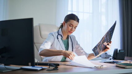 Satisfied woman radiologist studying scan clinic. Happy doctor analyzing x-ray