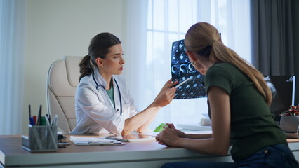 Practitioner explaining x-ray results closeup. Woman listening attentively lady