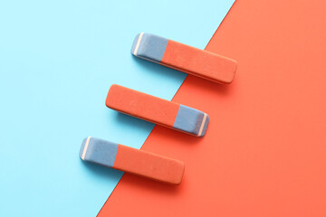 School erasers on color background