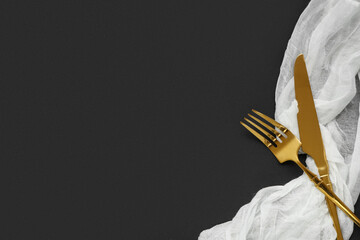 Stylish golden fork and knife on black background