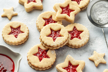 Christmas raspberry linzer cookies on white marble background. Festive dessert, winter treat