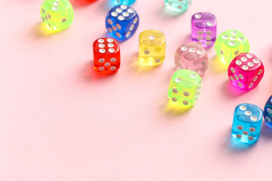Colorful game dices on pink background, closeup