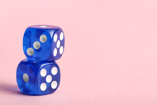 Blue game dices on pink background