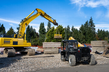 Heavy equipment operator using strap on excavator boom arm to remove box of scrap materials from foundation of stormwater retention system tank  © knelson20