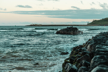 Waves crashing on rocky breakwater along ocean coast