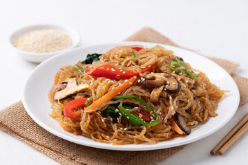 Japchae, Korean stir fried glass noodles with vegetables, pork, soy sauce and sesame seeds