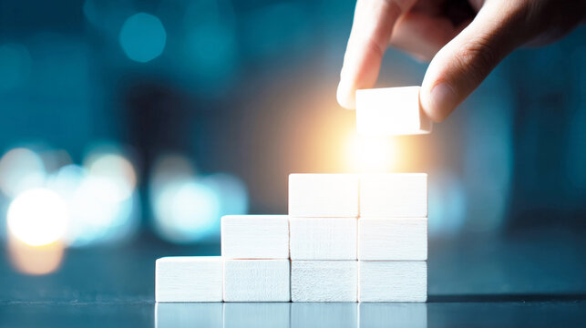 ブロックを積み上げビジネスの成功と成長を表現する手
