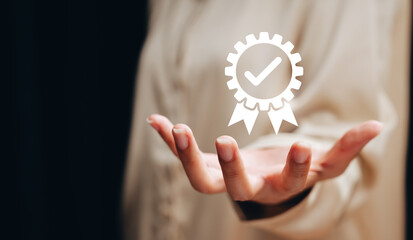 Quality assurance concept. Open hand holding virtual certification badge with check mark, service excellence, standard approval, customer trust, business credibility, quality control