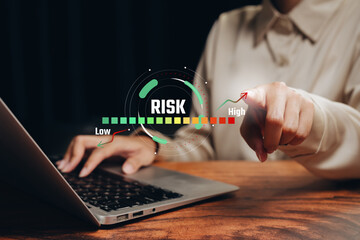 Risk management concept. Businesswoman using laptop with virtual risk meter interface, financial risk analysis, investment strategy, decision making, uncertainty control, business planning