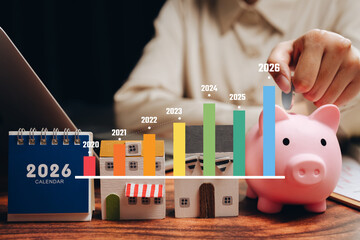 Financial growth concept. Hand putting coin into piggy bank with yearly growth chart and calendar, savings plan, long term investment, wealth management, financial goal, future planning