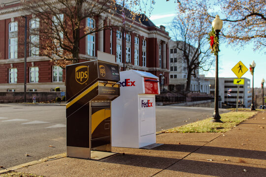 Outdoor UPS and FedEx drop boxes located on a downtown street during the holiday season. (Jefferson City, MO - Dec. 24, 2025). Editorial Use Only.