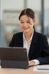 Asian Business woman using calculator and tablet laptop for doing math finance on an office desk, tax, report, accounting, statistics, and analytical research concept


