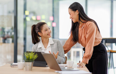 Fototapeta premium Two asian business man and woman is talking about work projects at office.account, net profit to plan new sales strategies to increase production capacity. 