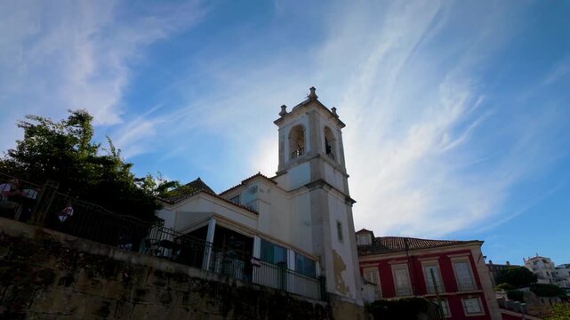 Low angle view of a historic church facade in Portugal with blue sky.