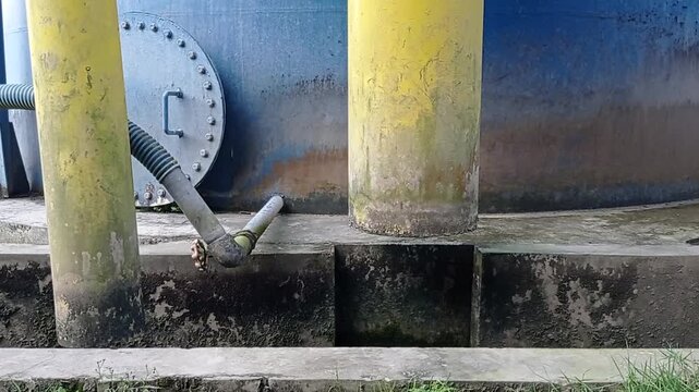 View of industrial backwash process: muddy water discharging from facility tank