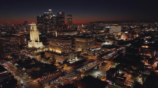 Flying over the city at night, buildings illuminated with colorful electric lights, city contraflow, and people living along its avenues and streets with cars