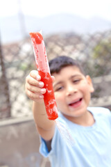 Happy latin boy holding fruit ice.