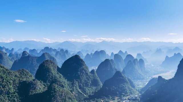 aerial time-lapse of the majestic karst landscape in Yangshuo, Guilin. Endless green peaks stretch into the distance under a clear blue sky, showcasing China&rsquo;s iconic natural beauty.