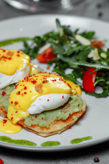 Sandwiches with avocado and poached egg, healthy breakfast.