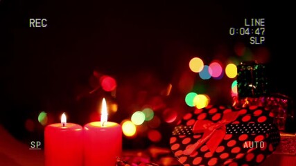 A festive and warm scene with burning red candles and blurred holiday lights
