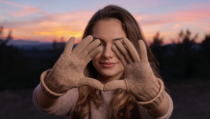 手袋の手が作るハートの形 夕暮れの光できらめく感情表現.生成AI