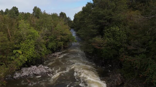 Low Drone Shot Between Trees Over Turbulent Muddy River
