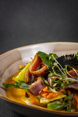 Pumpkin salad with dried duck, cherry tomatoes and pumpkin seeds. Close-up, selective focus