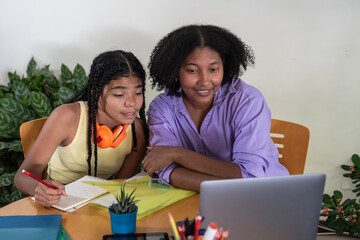 Mother and daughter learning online with a laptop