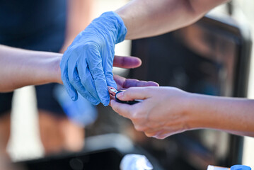Nurse pricking a patient's finger to perform a blood glucose test.