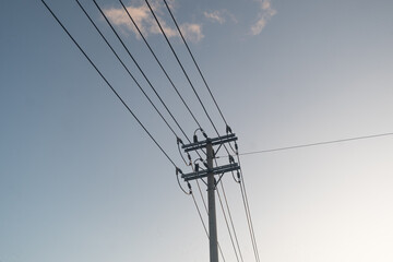 Fototapeta premium Power electric pole with line wire on colored background close up, photography consisting of power electric pole with line wire under sky, line wire in power electric pole for residential buildings