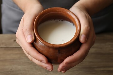 person hold clay pot of milk froth. Fresh farm dairy storage