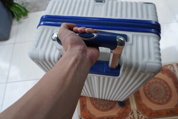 Hand holding suitcase