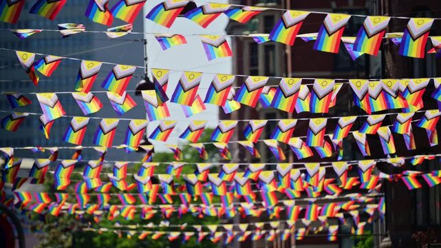 Progress pride flags hanging across a city street symbolizing community celebration and inclusion. Copenhagen, Denmark