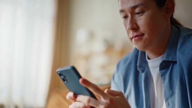 Closeup man fingers tapping smartphone at living room. guy looking cellphone