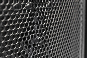 Close-up image of a textured metal surface with small holes and a pattern.