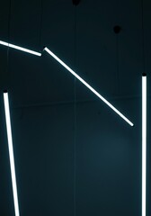 Modern artistic light installation hanging from the ceiling, creating an abstract glow and geometric shadows, innovation, atmosphere, wire