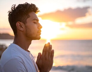 young man praying at sunset