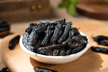 black raisins fruits on wooden table.