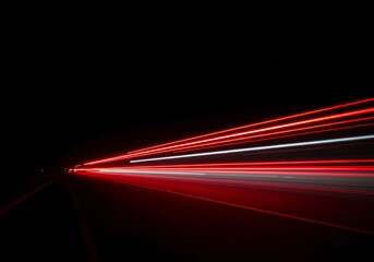 Dynamic long exposure photograph showing bright red and white light trails streaking across a dark, empty background, representing speed and motion, shutter speed, time, empty