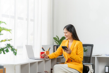 Office Bliss: A focused professional is seen gracefully navigating both a laptop and mobile phone, exemplifying the seamless integration of technology in the modern workplace.