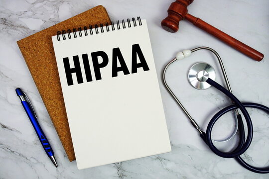 HIPAA text written on notepad with stethoscope and gavel on marble background
