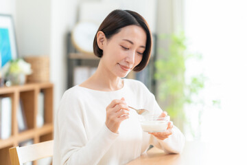 リビングでシリアルを食べるミドルの女性