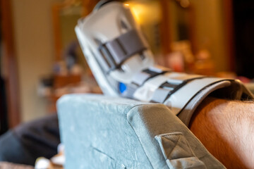 Elevated Foot in medical boot resting on a soft surface in a home setting during the day